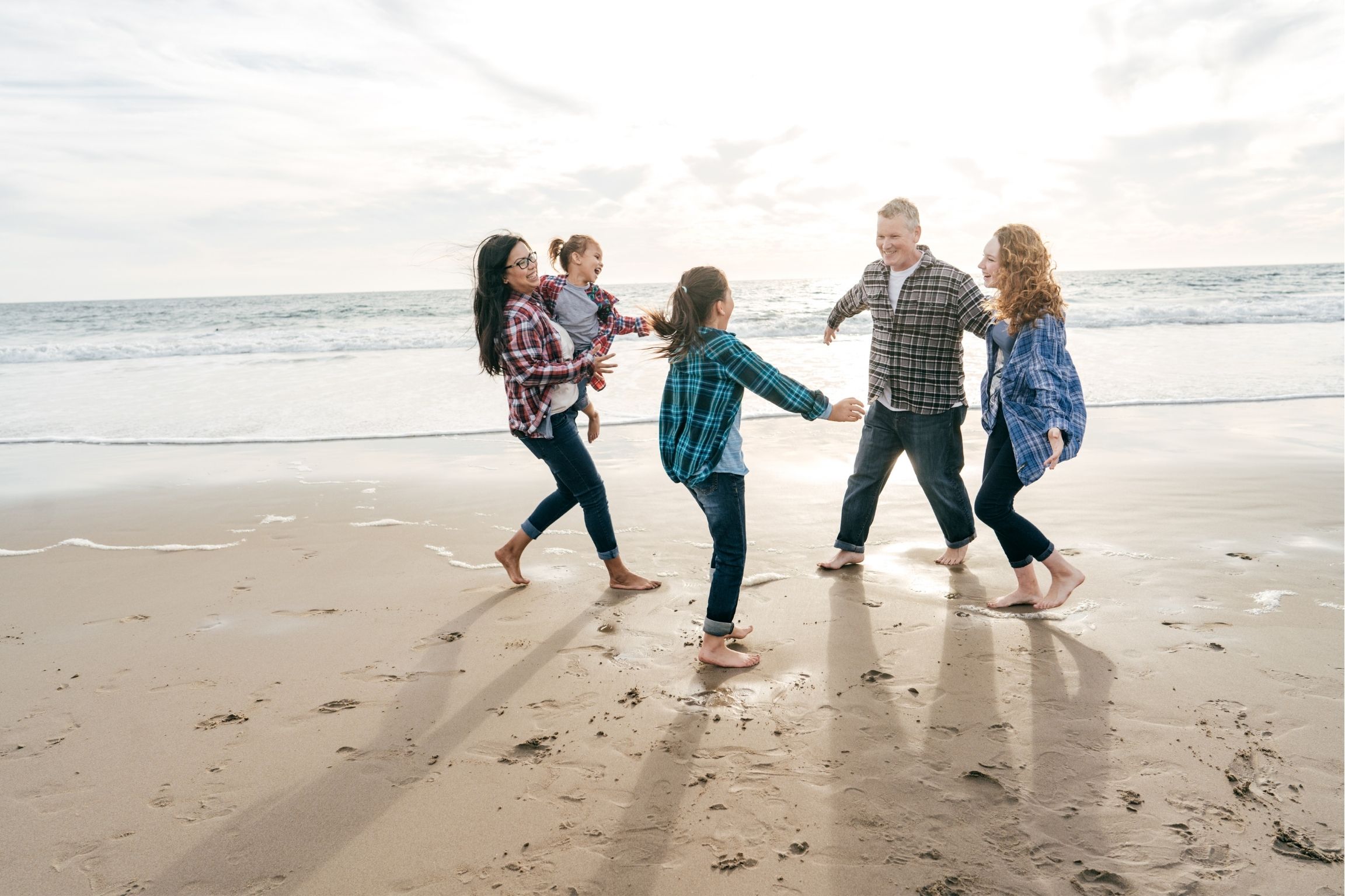 familia reunida feliz en la playa | asociación caer y levantarse